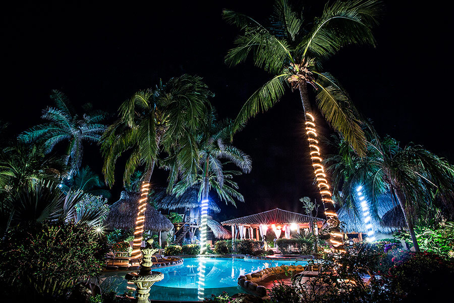Dramatic night time view of Present Moment with lights around pool