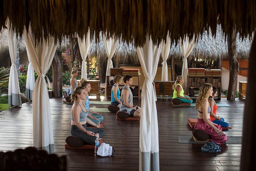 A class sits in the yoga pavillion and quietly meditates
